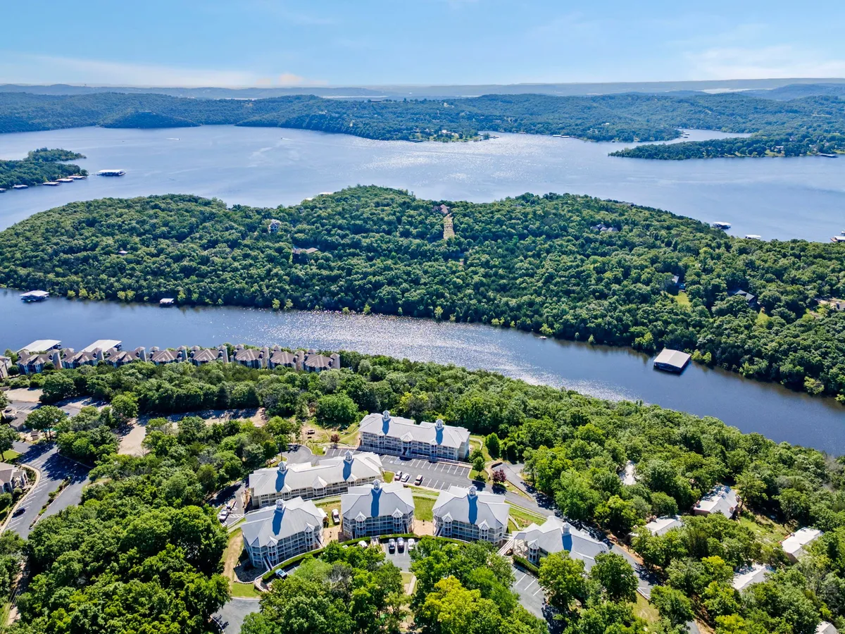 A tranquil lake scene framed by rolling hills and residential buildings, with the water inviting for boating, fishing, and lakeside relaxation. The natural surroundings offer ample space for outdoor exploration and dog-friendly walks.